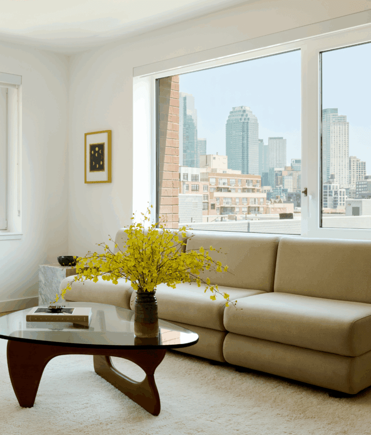 Living room with ornate furniture and yellow flowers in a vas with views of Long Island City