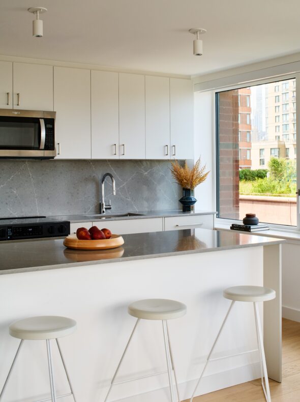 Kitchen Island with quartz granite countertops and three white barstools