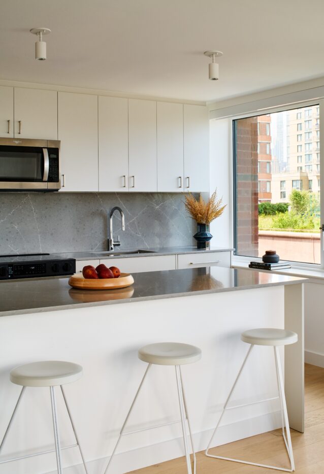 Kitchen Island with quartz granite countertops and three white barstools
