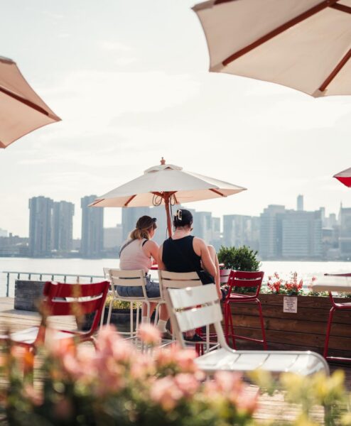 Two people seated and enjoying lunch at a waterfront Park